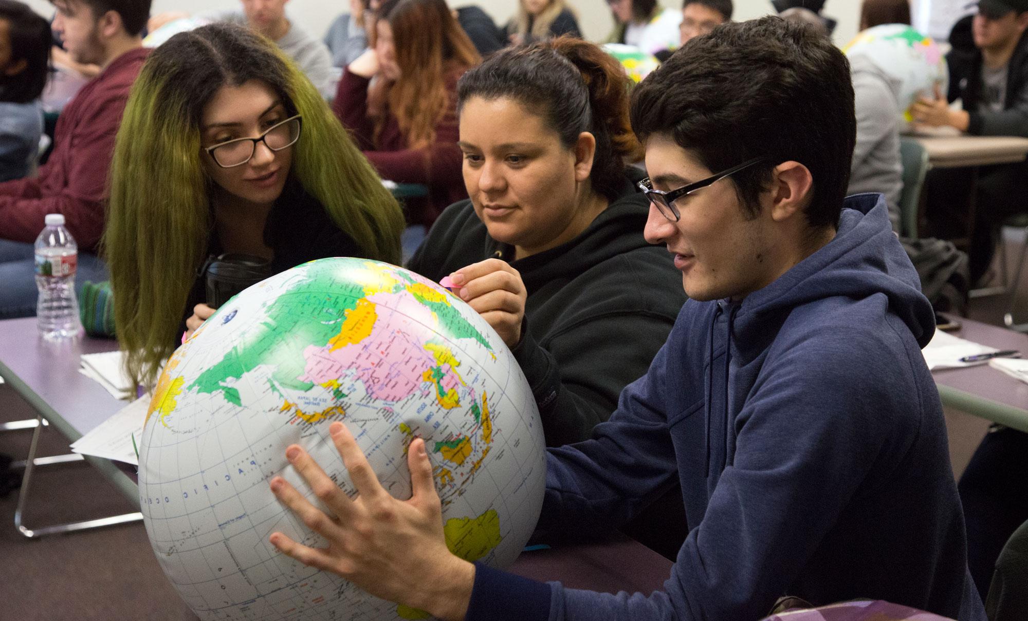 Students study a globe during class